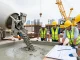 Workers collaborating on NAGA2000 concrete project, showcasing heavy machinery and safety protocols